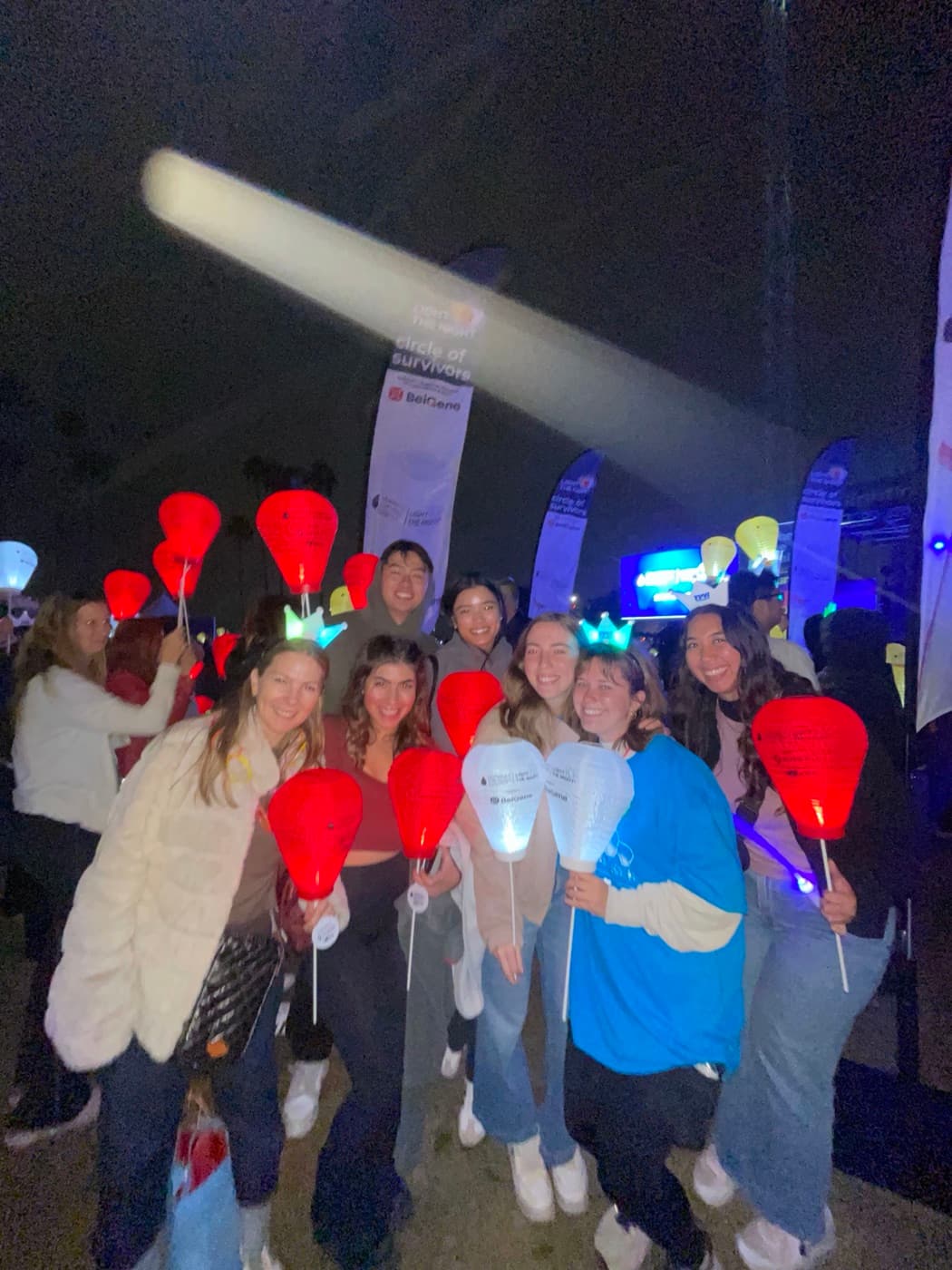 Natalia with friends at a Light the Night walk, holding illuminated lanterns